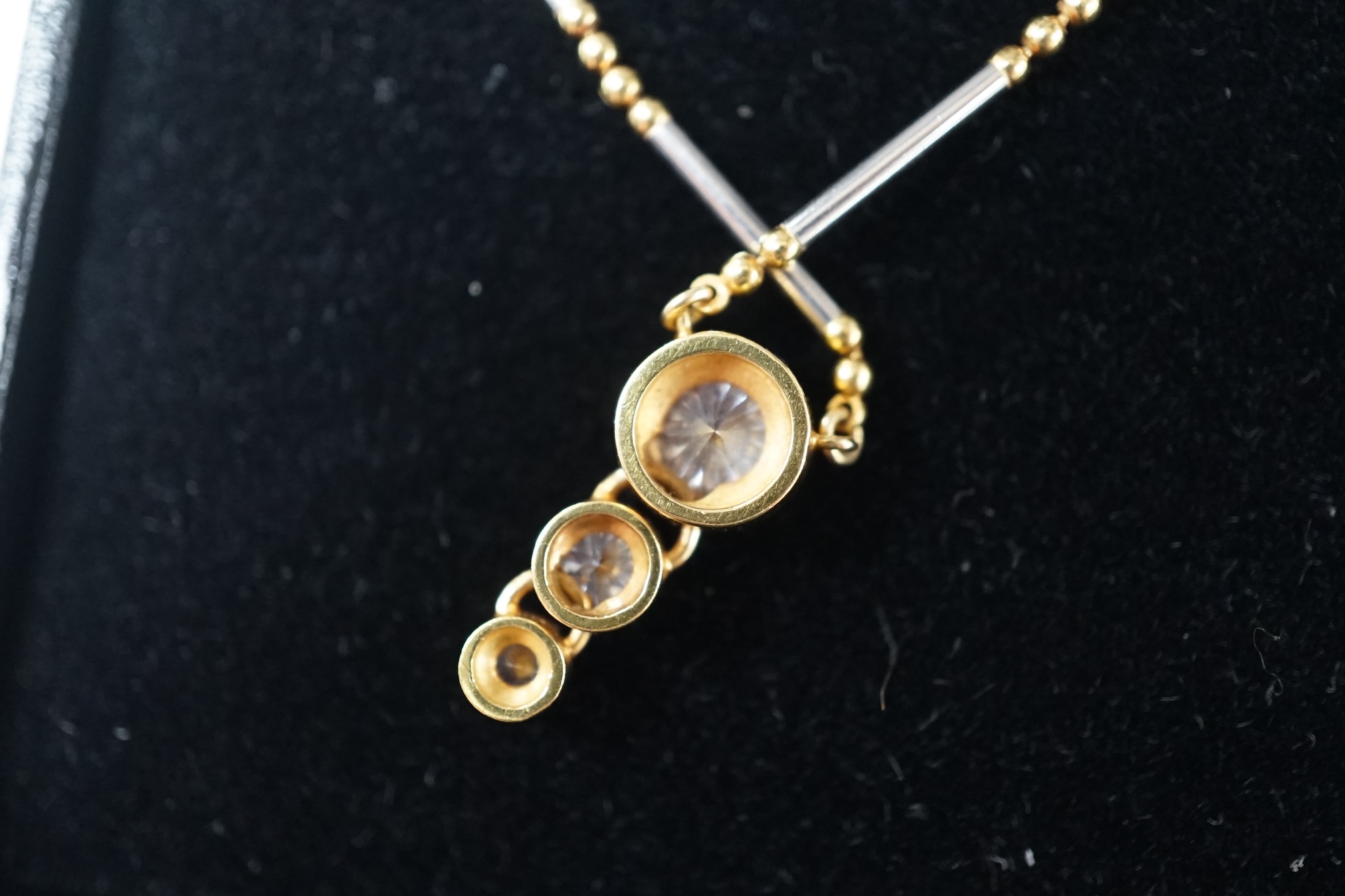 A modern yellow and white metal (stamped 18kt and Pt850), graduated three stone diamond set pendant necklace, 42cm, gross weight 7.1 grams and a an Italian Uno-A-Erre 18ct gold and solitaire diamond set necklace, 46cm, g